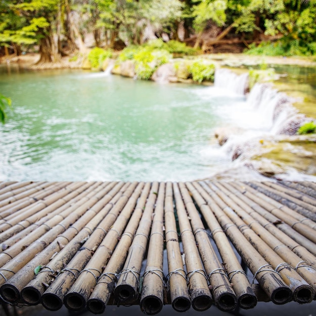 Bamboe houten brug op vervagen waterval natuur achtergrond