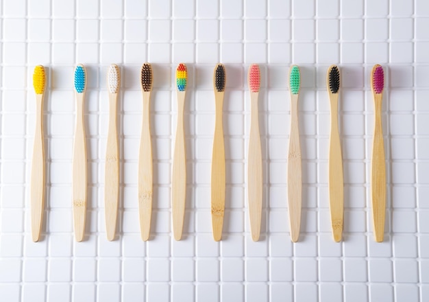 Foto bamboe tandenborstels met veelkleurige haren op tegels in de badkamer