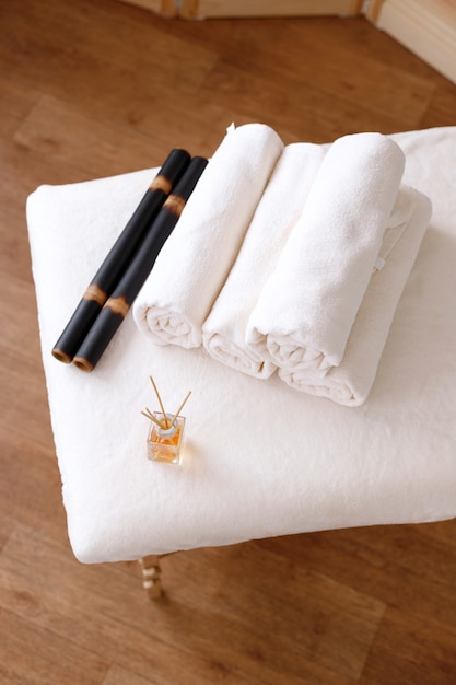 Bamboestokken, handdoeken en aroma-olie op de massagetafel