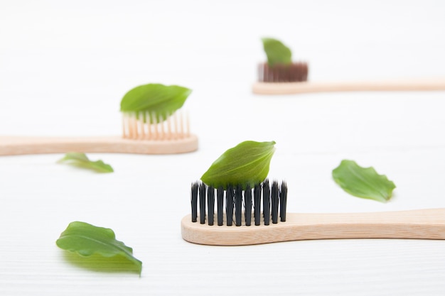 Bamboo brushes with moldings on a light background, a sheet on the brush like toothpaste, zero waste concept, natural cosmetics