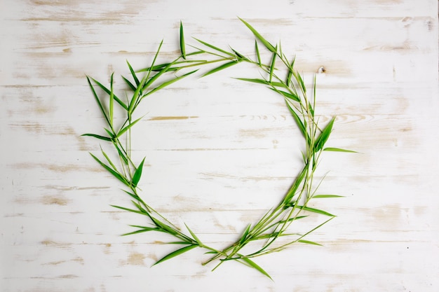 bamboo leaves frame border with white wooden background texture