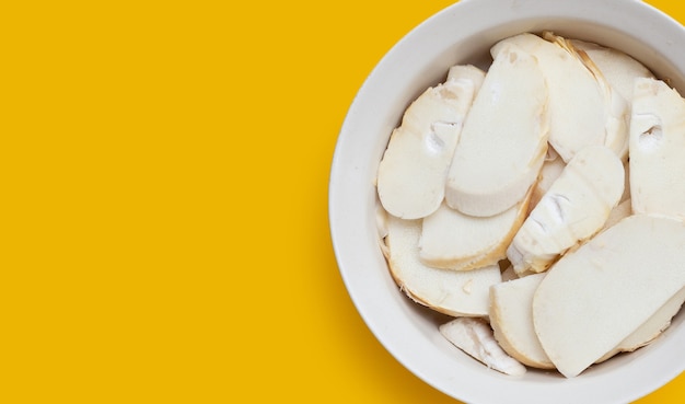 Bamboo shoots in white bowl on yellow background
