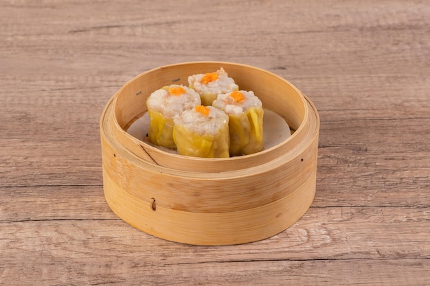 A bamboo steamer with a piece of dumplings in it.