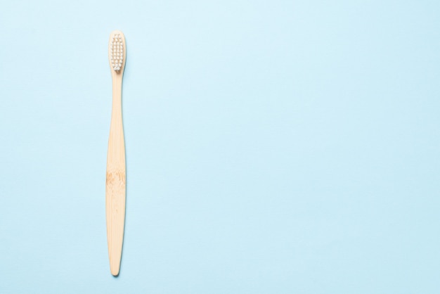 Bamboo toothbrush on a blue background. Top view.