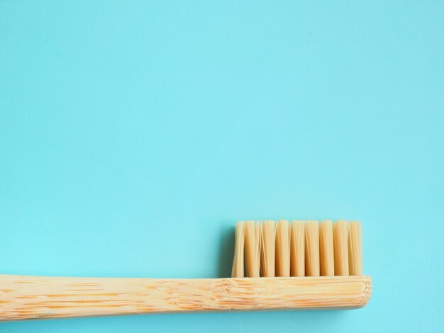 A bamboo toothbrush on a blue background
