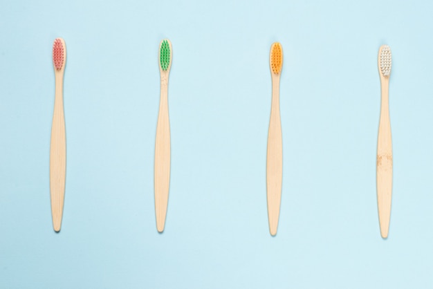 Photo bamboo toothbrush on a blue surface. top view.