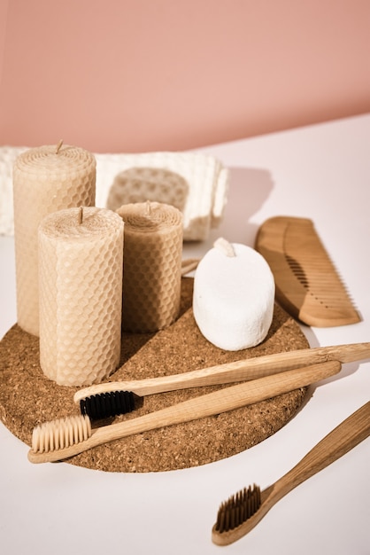 Bamboo toothbrushes and candles on pink background. Reuse natural products