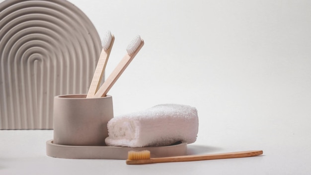 Bamboo toothbrushes in a stylish concrete glass on a white background