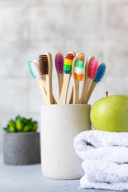 Photo bamboo toothbrushes with towel plant and apple biodegradable care products no plastic concepts