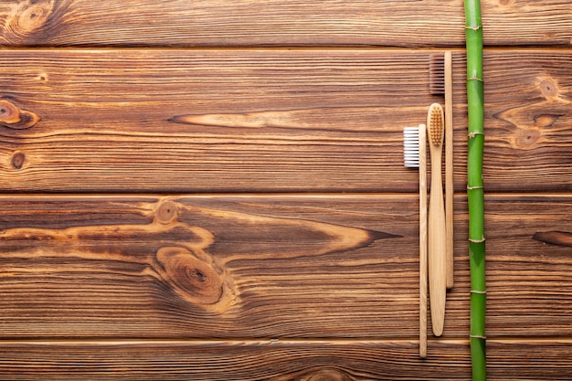木製の背景に竹の歯ブラシフラットレイコピースペースナチュラルバスエコ製品