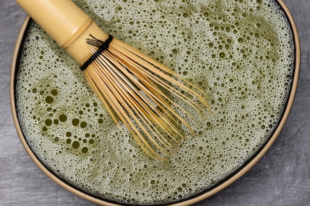 Bamboo whisk in a bowl with matcha tea