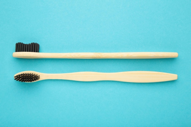 Spazzolino da denti in legno di bambù con setole nere su sfondo blu