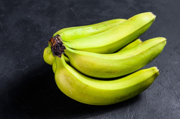 Banaan genaamd guineo of bocadillo (Musa acuminata). Zwarte achtergrond. Bovenaanzicht Ruimte voor tekst. Tropisch fruit.