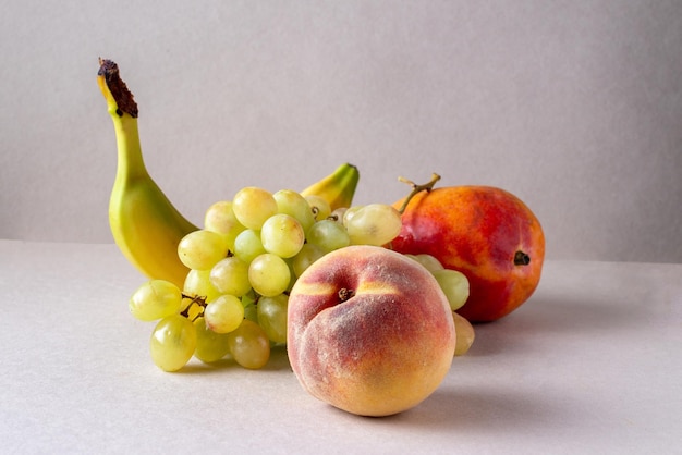 Banaan groene druiven mango perzik staan op tafel