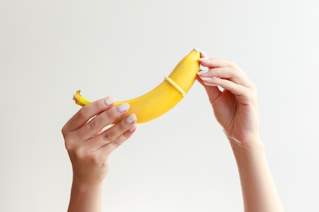 Banaan met een condoom op een witte achtergrond. seksuele voorlichting