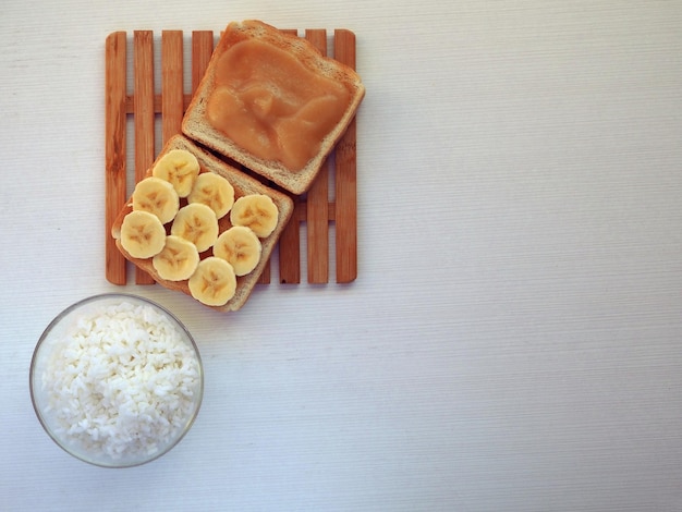 Banaan rijst appelmoes en toast op een witte achtergrond