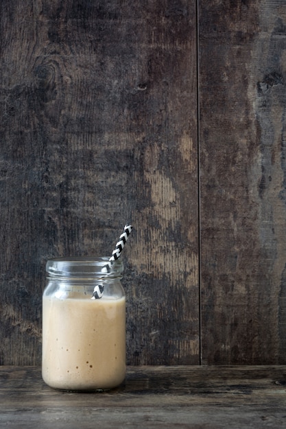 Foto banaan smoothie in pot op houten tafel kopie ruimte