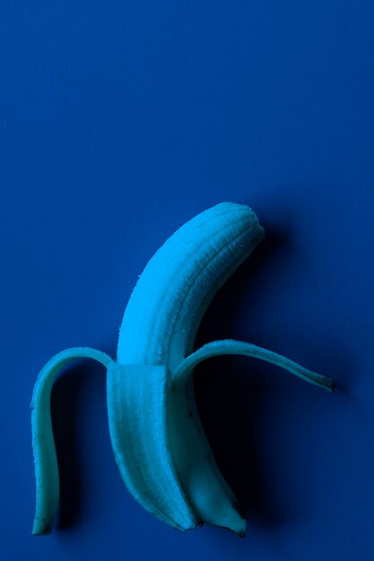 Banana on blue paper background dark blue tones image