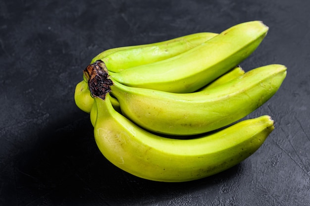 기니 또는 보카 딜로 (Musa acuminata)라고 불리는 바나나. 검정색 배경. 평면도. 텍스트를위한 공간입니다. 열대 과일.