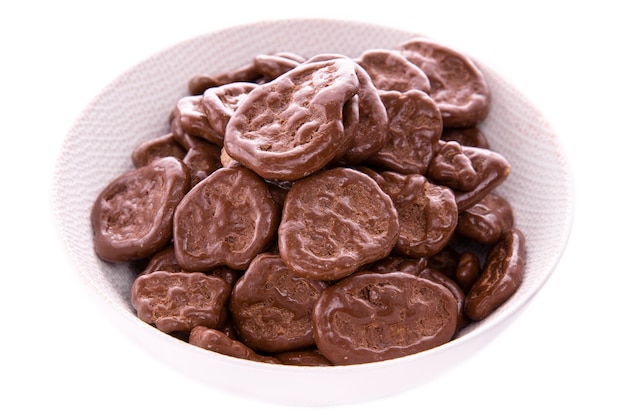 Banana chips in chocolate, in a white plate on a white background, isolated products