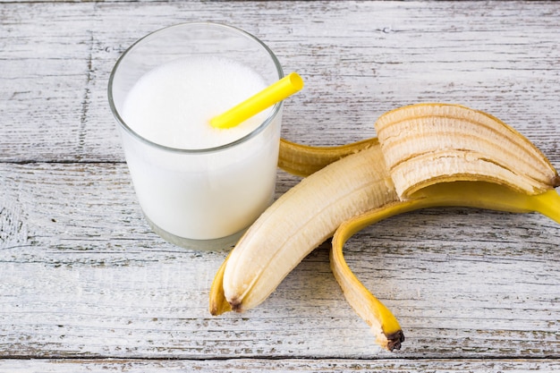 Banana cocktail and fresh bananas on wooden