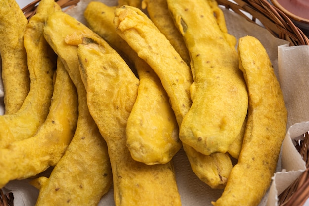 Banana Fritter or pakora or raw kela pakodaÃÂ or bajji served with chutney. Popular snack from Kerala, India or Indonesia. served with tea