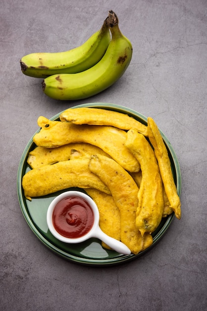 Banana Fritter or pakora or raw kela pakodaÃÂÃÂ or bajji served with chutney. Popular snack from Kerala, India or Indonesia. served with tea