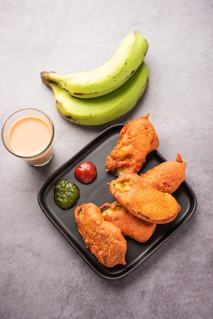 Banana Fritter or pakora or raw kela pakodaÃÂ or bajji served with chutney. Popular snack from Kerala, India or Indonesia. served with tea