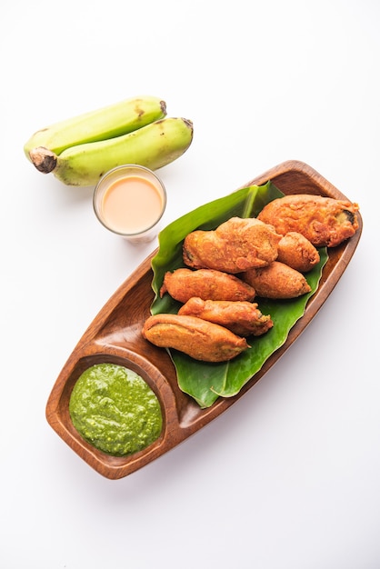 Banana Fritter or pakora or raw kela pakodaÃÂ or bajji served with chutney. Popular snack from Kerala, India or Indonesia. served with tea