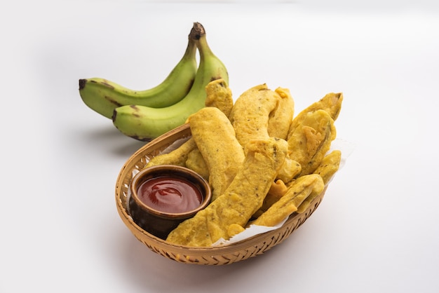 バナナフリッターまたはパコラまたは生のケラパコダまたはバジがチャツネと一緒に出されます。ケララ州、インド、インドネシアで人気のスナック。お茶を添えて