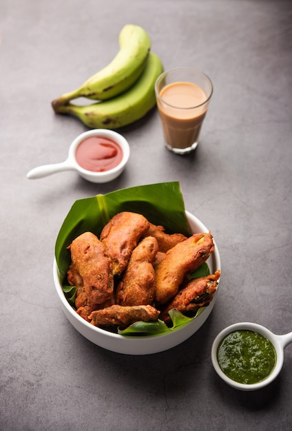 Banana Fritter or pakora or raw kela pakodaÃÂ or bajji served with chutney. Popular snack from Kerala, India or Indonesia. served with tea