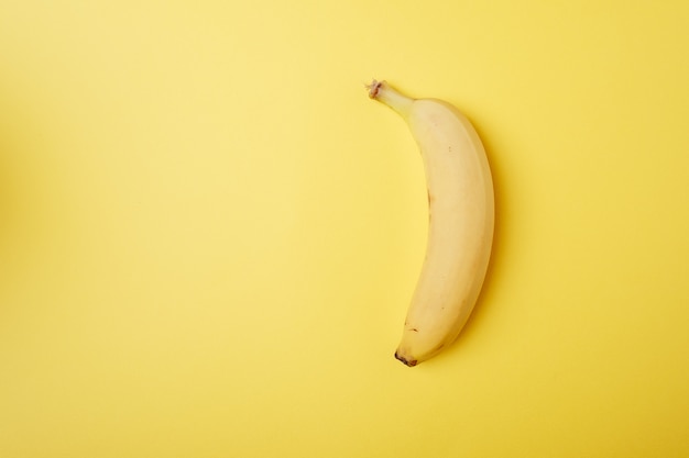 Photo banana fruit on yellow background isolated