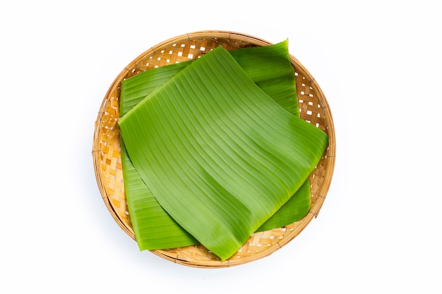 Banana leaf on bamboo basket on white