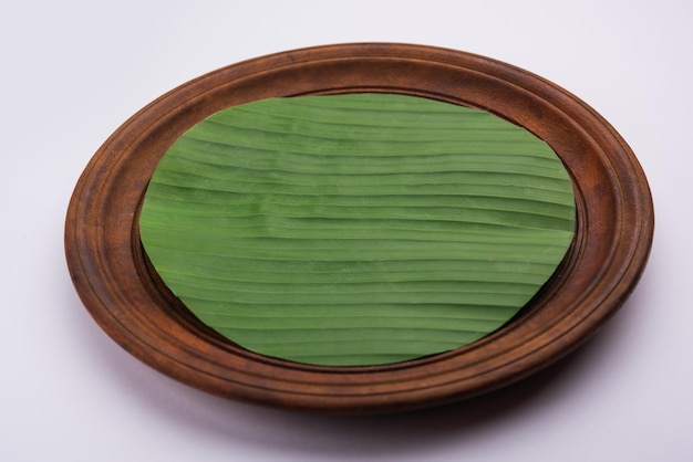 Banana leaf on blank plate for edit food or subject on