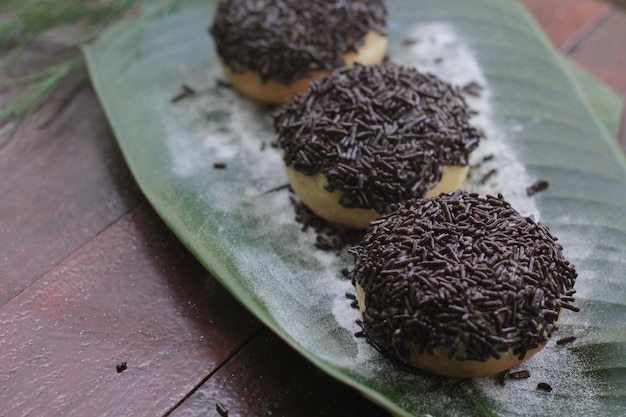 A banana leaf with three doughnuts on it