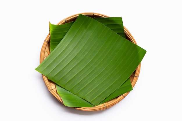 Banana leaves in bamboo basket on white background.