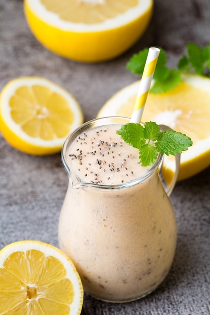 Banana and lemon smoothie, on the grey  table.