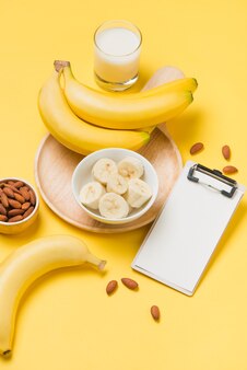 Banana e latte su sfondo di carta gialla con appunti in bianco per il testo