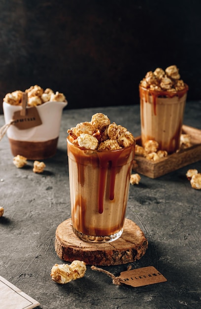Banana milkshake with caramel and popcorn on a dark background Selective focus