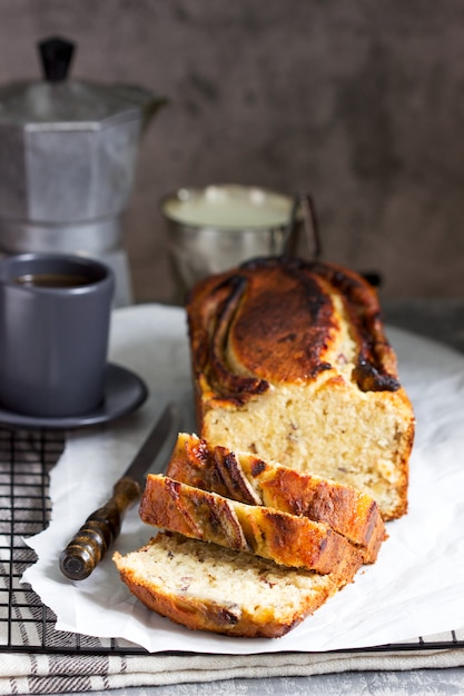 Banana muffin with candied ginger and raisins and drinks on a gray background.