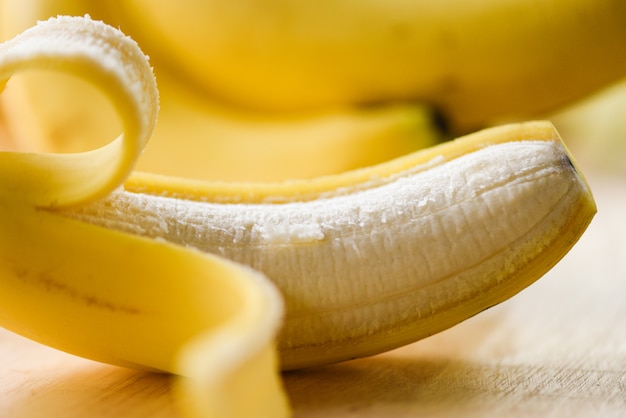 Banana peel  - 木の板に皮をむいた新鮮な完熟バナナ果実を閉じる