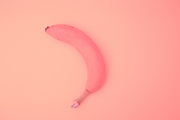 Banana in a pink shade on a pink background