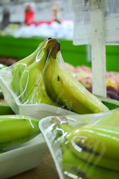 Banana in plastic wrap displayed in supermarket