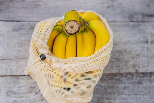 スタイリッシュな木製キッチンの表面に再利用可能なバッグに入ったバナナ 廃棄物ゼロのコンセプト プラスチックフリーのコンセプト