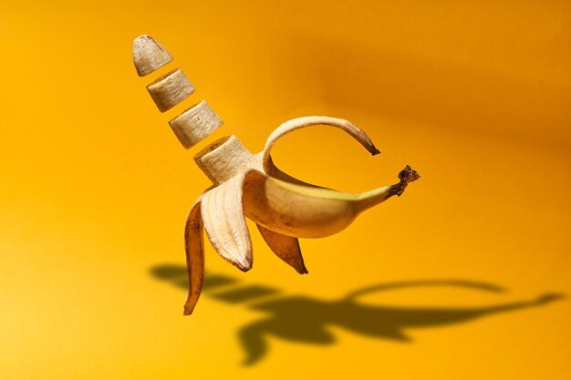 Foto fette di banane che volano su uno sfondo giallo