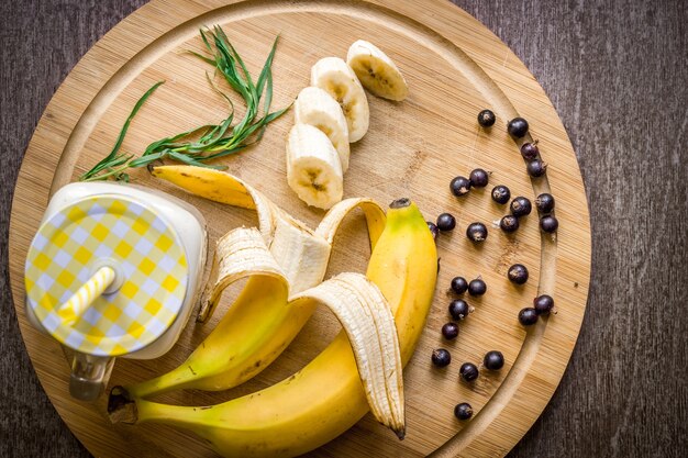 Banana smoothie and fresh banana on wooden table