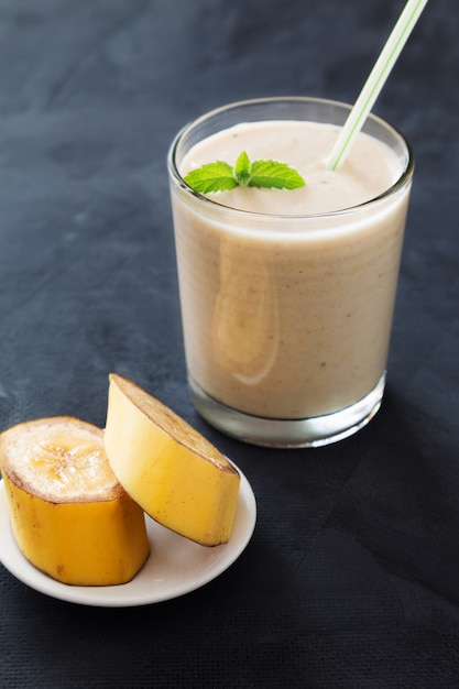 Banana smoothie with mint on dark background