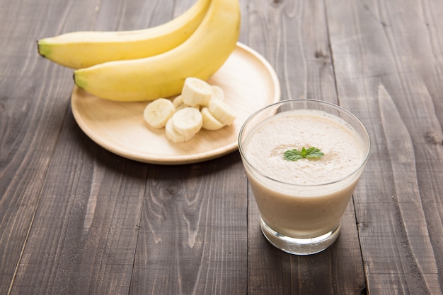 Banana smoothie on wooden table.