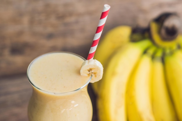 Foto frullati di banana e banane su un vecchio sfondo di legno.