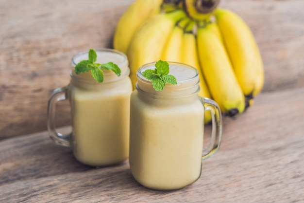 Banana smoothies and bananas on an old wooden